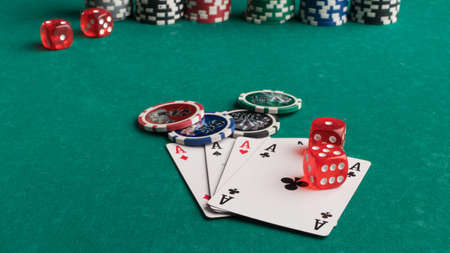 Poker chips, cards and dice on a green background. The concept of gambling and entertainment. Casino...