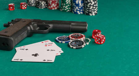 Poker chips, cards and gun on a green background. The concept of gambling and entertainment. Casino...