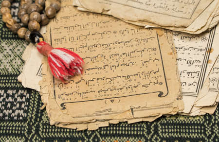 Muslim prayer beads with ancient pages from the Koran. Islamic and Muslim concepts. Ancient old sheets of paper from the Arabic bookの写真素材