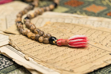 Muslim prayer beads with ancient pages from the Koran. Islamic and Muslim concepts. Ancient old...