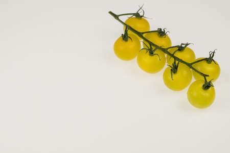 fresh yellow cherry tomatoes on a white background. wet tomatoesの写真素材