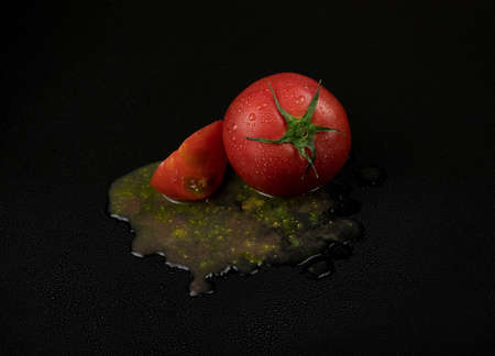 fresh wet tomatoes on a black background. sliced tomatoes with pulpの写真素材