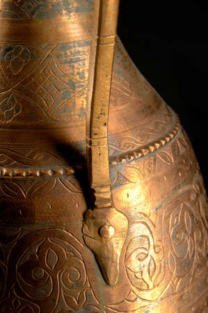 Part ancient oriental metal jug on dark background. Antique bronze tablewareの写真素材
