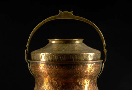 Ancient metal bowl on dark background. Antique bronze tablewareの写真素材