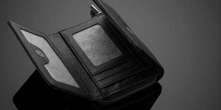 A closeup of a fashionable leather wallet on a dark background