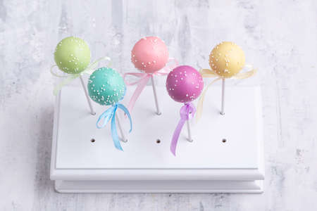 Colorful cake pops on a textured background