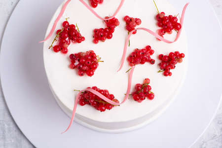 A top view shot of a white cake designed by red berry on a white plateの写真素材