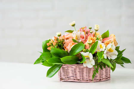 A closeup of a beautiful composition with alstroemerias, roses, and green leaves