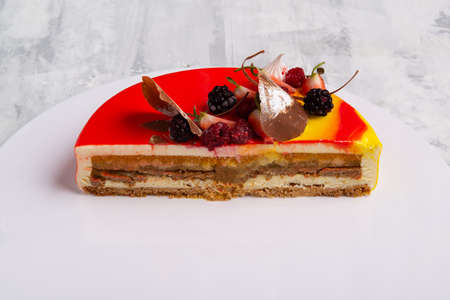 A closeup shot of a tasty cake topped with candies and fresh fruits