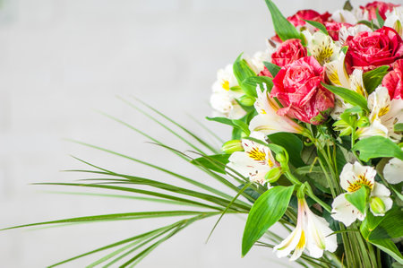 A closeup of a beautiful bouquet with roses and white alstroemeria isolated on a white backgroundの写真素材