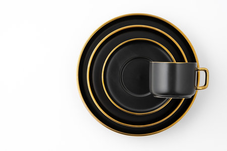 A set of black and golden ceramic plates and cups on a white background. top viewの写真素材