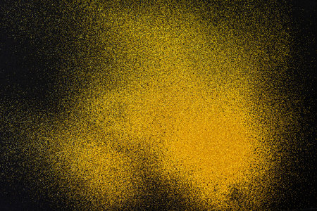 A minimal golden sand texture on a black backgroundの写真素材