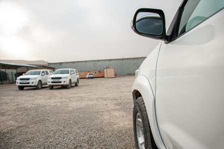 A closeup of an car door and rear view mirror at a construction site