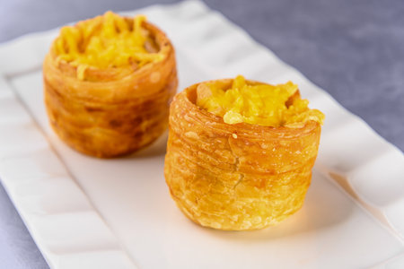 A sweet crispy dough with cream filling on white plate