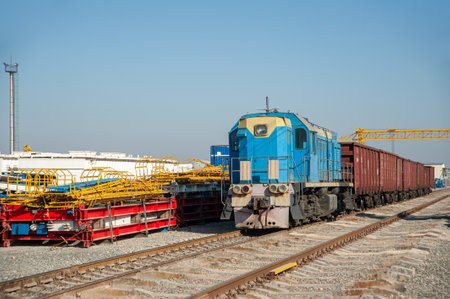 An old train on the railway tracks in the industrial construction on a sunny dayの写真素材