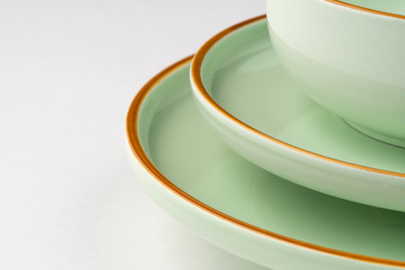 A set of pastel green ceramic tableware with orange outlines. close-upの写真素材