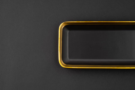 A set of black and golden ceramic plate on a black background. top viewの写真素材
