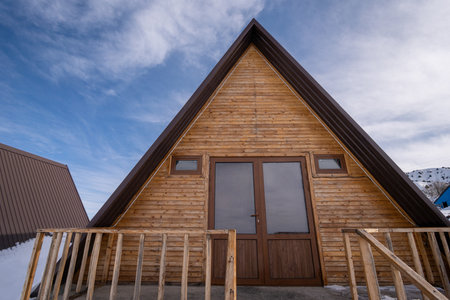 The close-up wooden cottages surrounded by snow. A recreational area in the mountainsの写真素材