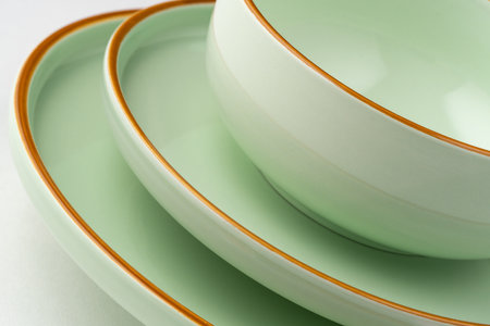 A set of pastel green ceramic tableware with orange outlines. close-upの写真素材
