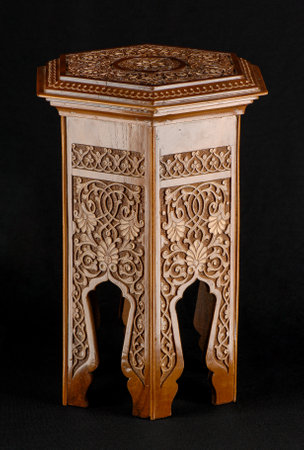 A vintage oriental wooden table with artistic carving isolated on a black backgroundの写真素材