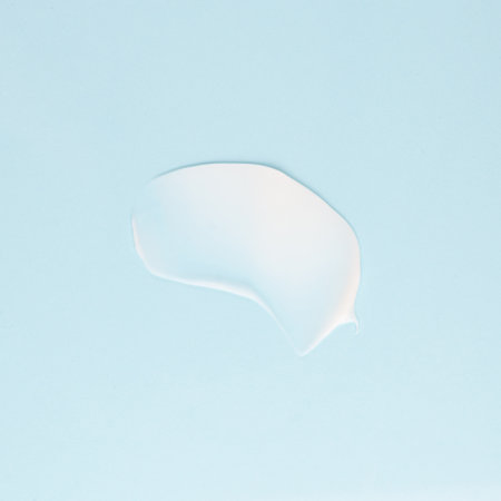 Smear of white cream for face and body on a blue backgroundの写真素材