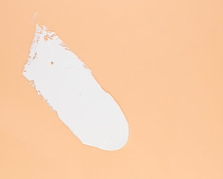 Smear of white cream for face and body on a brown backgroundの写真素材