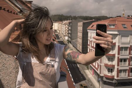 girl taking a photo on the terrace of a building in the city