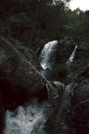 natural water waterfall following a stone path in the bush