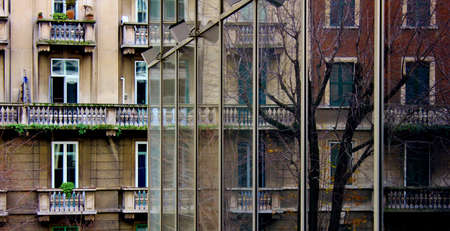 old facades reflected on the windows of a new buildingの写真素材