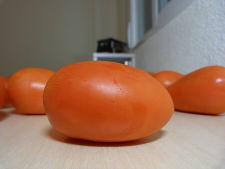 Macro photo of a tomato with some tomatoes in the backgroundの写真素材