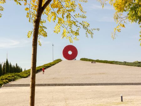 Photo of a sculpture of a red donut in a park