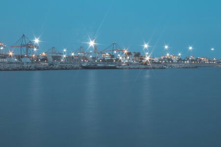 Photo of an industry port with water in foregroundの写真素材
