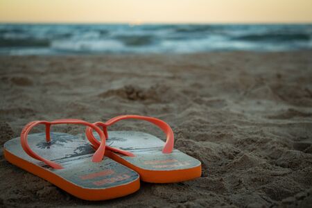 Photo of flip flops with the sand in the beachの写真素材