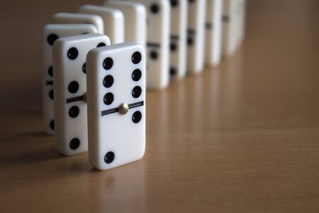 Domino Tiles Standing in Line on Wooden Tableの写真素材