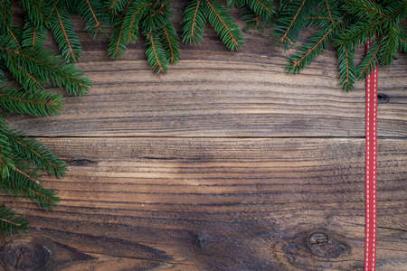 Pine tree with red ribbon on old wooden backgroundの写真素材