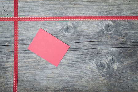 Red christmas ribbon on old wooden backroundの写真素材