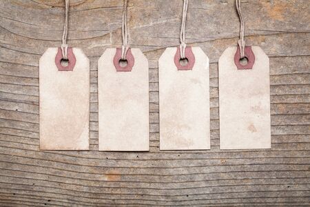 Assortment of vintage tags and labels with texture and stain details.Wood backgroundの写真素材