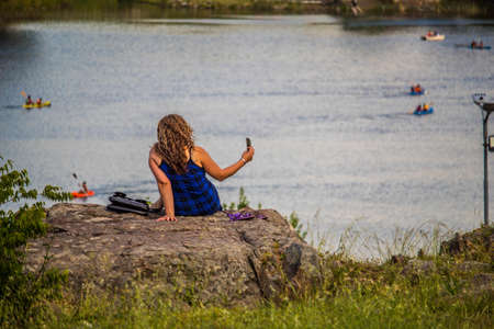 Woman taking a selfie in the lake.の写真素材