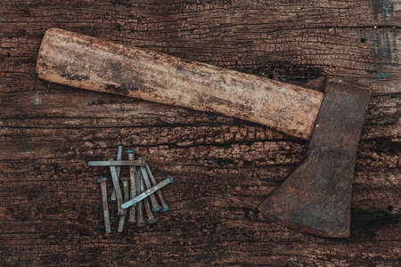 Ax and nails over a wooden table.の写真素材