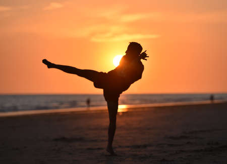 a fighter training on the beach at sunsetの写真素材