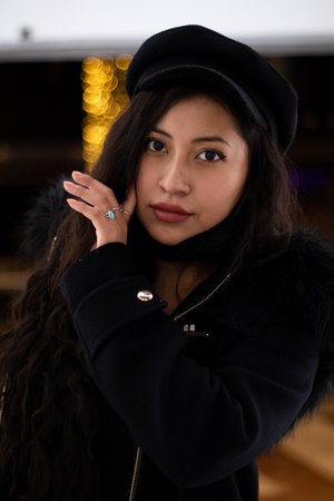 Pretty Latina girl shopping in a mall looks towards the camera while holding her hair in her hand.