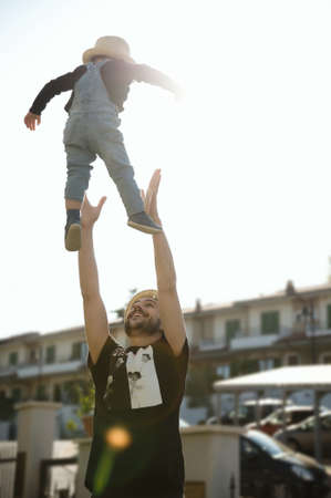 Staying at home: a father and his young son playing together in the backyard.