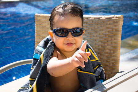 Baby sunglasses swimming pool asking for a drinkのeditorial素材