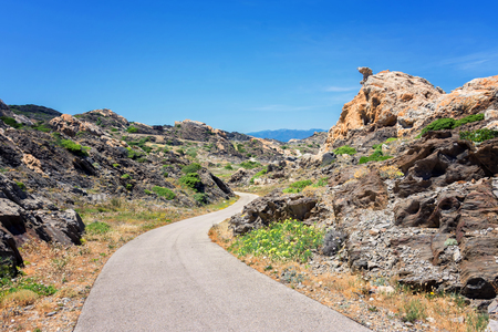 view of a street crossing the rocks in the natural park of Cap de Creus in Catalonia (Spain)の写真素材
