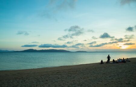 Group of friends watching the sunset at the beachの写真素材