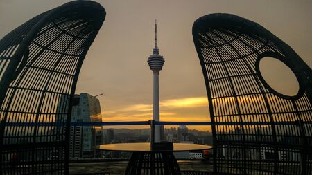 Two chairs on a rooftop at sunsetの写真素材