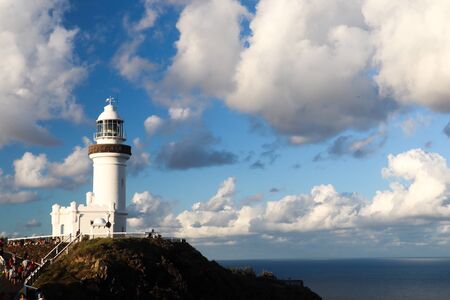 Lighthouse on top of a cliff on a cloudy dayの写真素材