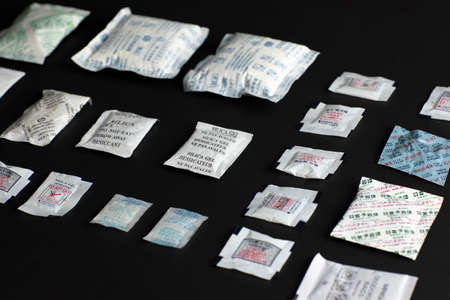 Desiccant or silica gel indifferent packaging and spread on black background.のeditorial素材