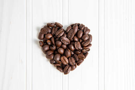 hart shape coffee beans in over a wood backgroundの写真素材