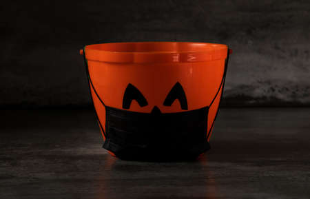 halloween kid's basket with protective face mask, COVID-19 protection, black background isolated, copy space.の写真素材